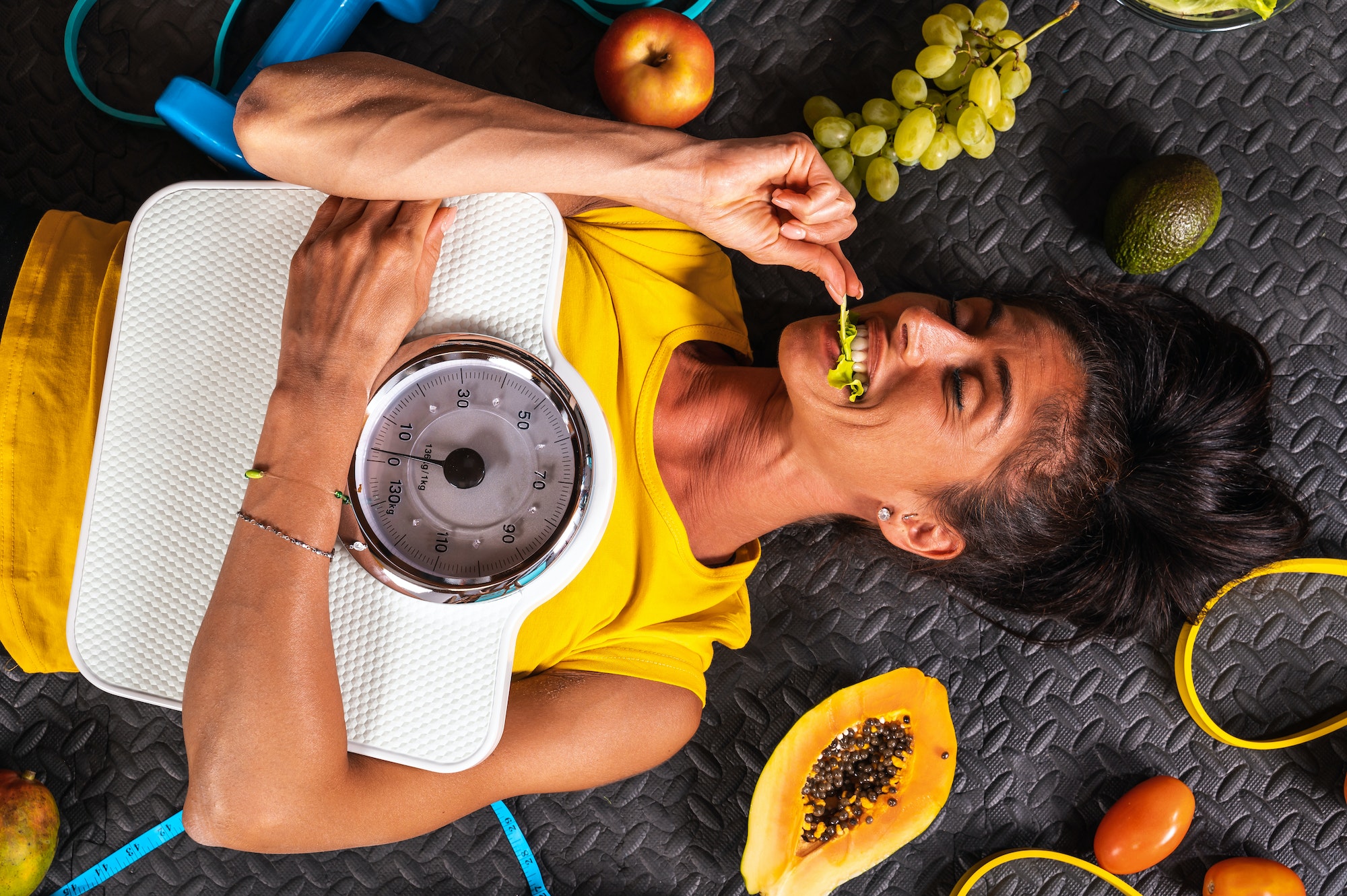 Happy woman eat healthy and trains in the gym